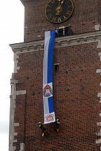 Flagę Krakowa w herbami zawodowych i ochotniczych straży pożarnych rozwinęli na wieży Ratuszowej dwaj strażacy... 
