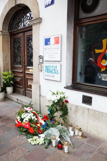 Kwiaty i znicze pod konsulatem Francji przy ul. Stolarskiej