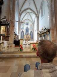 Na zdjęciu mieszkaniec na wózku na tle prezbiterium, tuż przed rozpoczęciem Eucharystii