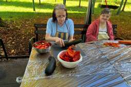 Na zdjęciu mieszkanki podczas obierania cukinii oraz marchwi w ogrodzie mieszkańców z DPS Praska 25