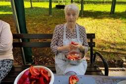 Na zdjęciu mieszkanka podczas krojenia papryki w ogrodzie DPS Praska 25. Zdjęcie wykonane przez pracownika DPS.