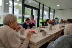 Na zdjęciu mieszkańcy podczas degustacji kiszonek wraz z zaproszonymi sąsiadami z Praskiej 25 w pokoju dziennym naszego Domu.