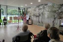 Na zdjęciu mieszkańcy słuchają gry na flecie poprzecznym.