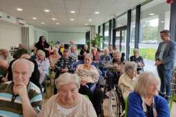 Na zdjęciu mieszkaniec, p. Marek siedzący wśród innych mieszkańców śpiewa piosenkę do mikrofonu, zarówno po francusku jak i po polsku. 