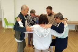 Na zdjęciu mieszkańcy tańczący w kręgu wspólnie z pracownikiem. 