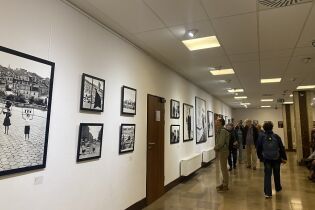 Uczestnicy zapoznający się z wystawą Krakowskiego Klubu Fotograficznego „75 lat Nowej Huty”