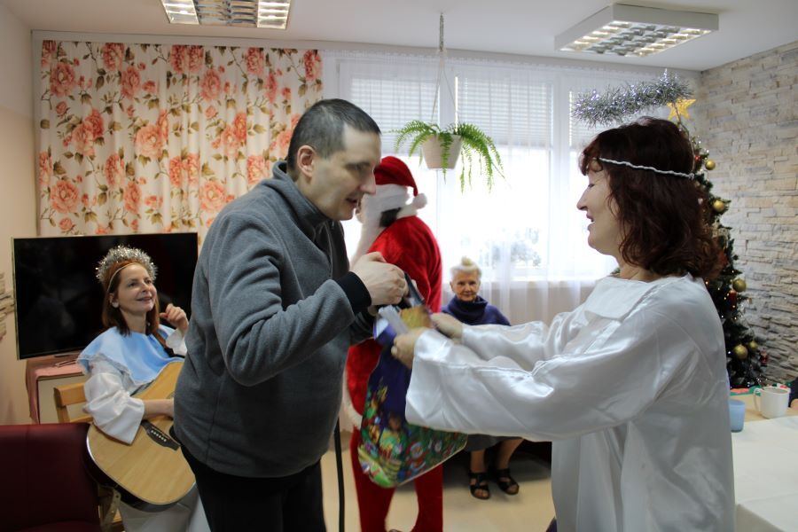 Mężczyzna otrzymujący prezent od kobiety w przebraniu anioła. 