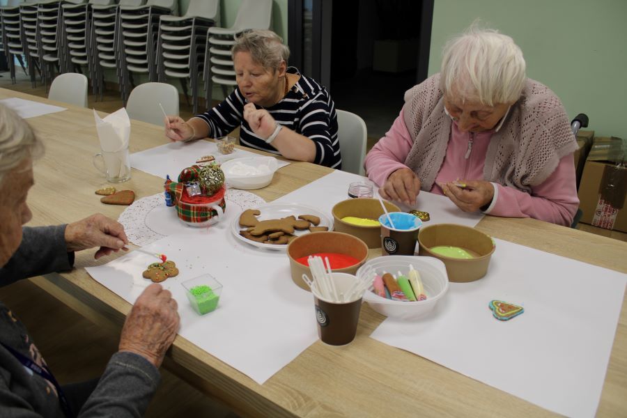 Trzy kobiety ozdabiające lukrami pierniki.