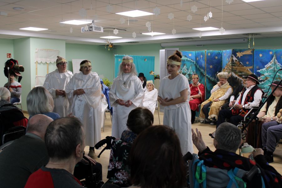 Dwie kobiety i mężczyzna w strojach biblijnych siedzą na scenie. W dłoniach trzymają scenariusze.