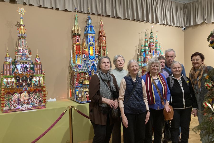 Seniorzy na tle szopek, które zostały wyróżnione w kategorii „Szopki duże”