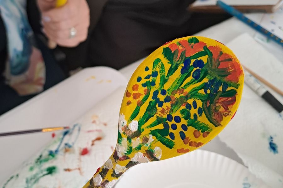 Zdjęcie przedstawia łyżkę wymalowaną w motywy roślinne