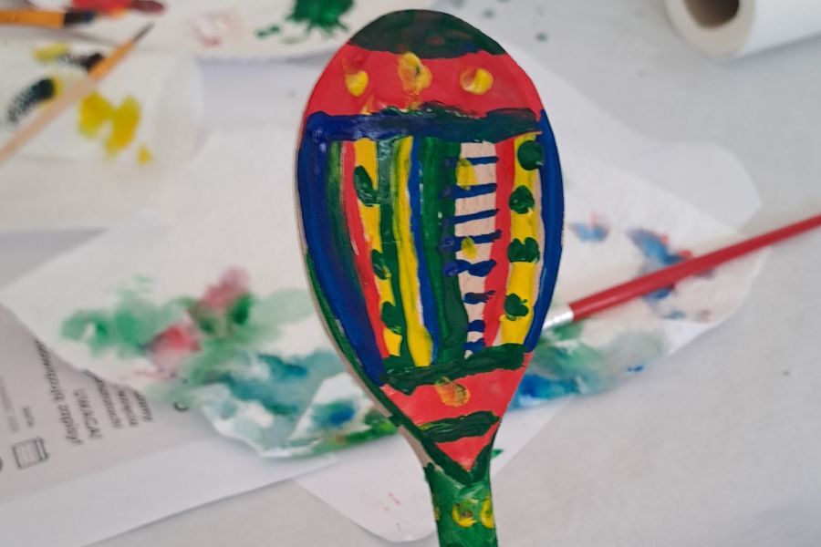 Zdjęcie przedstawia łyżkę wymalowaną w motywy łowickie