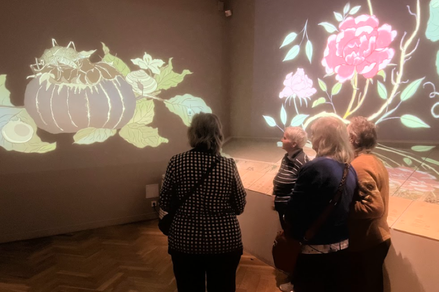 Uczestniczki przyglądają się tradycyjnym motywom roślinnym.