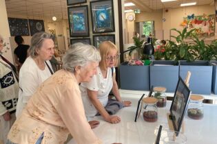 Panie podziwiają wykonane przez artystkę prace