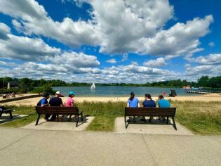 Uczestniczy siedzą na ławce 