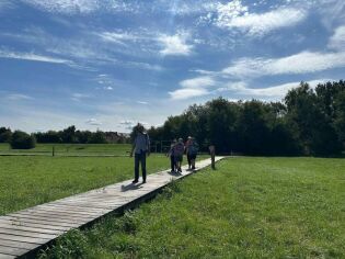 Uczestnicy spacerują po szlaku ścieżki sensorycznej