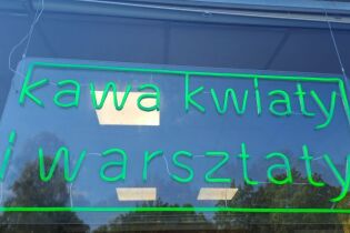 zdjęcie przedstawia szyld Kawiarni – nawiązanie szyldu do  neonów w Nowej  Hucie