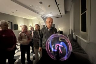 Uczestnicy oglądają kulę plazmową