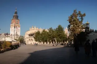 Krakowski rynek z wieżą ratuszową i budynkami w słoneczny dzień.
